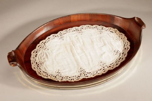 An oval mahogany serving tray featuring staved wood construction, twin carved side handles, and two horizontal brass bands securing the outer rim. View IX