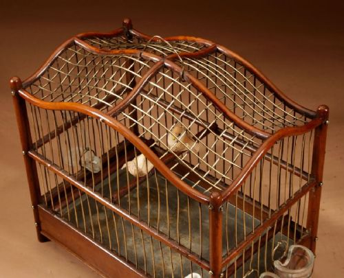 An Anglo-Dutch mahogany and brass birdcage featuring an arched wire dome roof, slide-out drawer tray, wooden perches, and accompanying glass vessels. View III