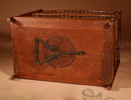 An Anglo-Dutch mahogany and brass birdcage featuring an arched wire dome roof, slide-out drawer tray, wooden perches, and accompanying glass vessels. View X