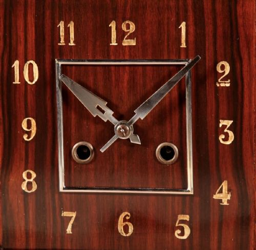 fig 1. An Art Deco Amsterdam School mantel clock featuring geometric oak and dark Macassar ebony wood veneer with brass numerals and angular hands.