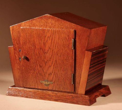 An Art Deco Amsterdam School mantel clock featuring geometric oak and dark Macassar ebony wood veneer with brass numerals and angular hands. View V
