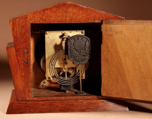 An Art Deco Amsterdam School mantel clock featuring geometric oak and dark Macassar ebony wood veneer with brass numerals and angular hands. View VI