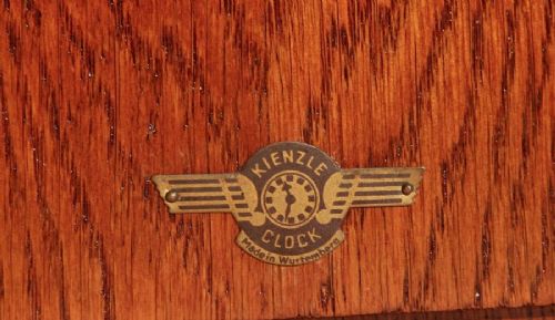 An Art Deco Amsterdam School mantel clock featuring geometric oak and dark Macassar ebony wood veneer with brass numerals and angular hands. View VII