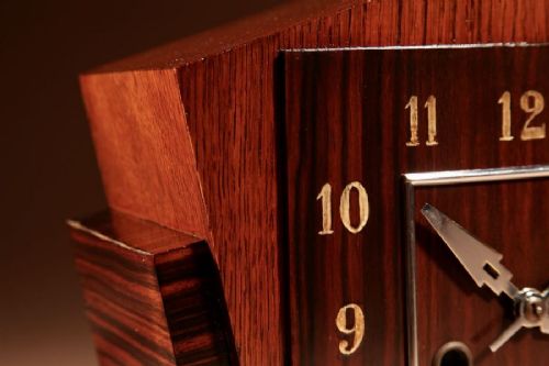 An Art Deco Amsterdam School mantel clock featuring geometric oak and dark Macassar ebony wood veneer with brass numerals and angular hands. View VIII