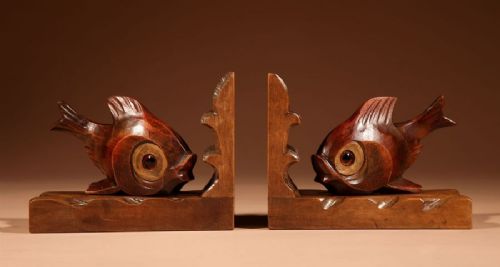 A pair of carved brown wooden bookends depicting goldfish figures mounted on angular wooden bases. View II