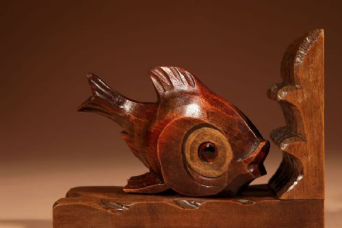 A pair of carved brown wooden bookends depicting goldfish figures mounted on angular wooden bases. View IV