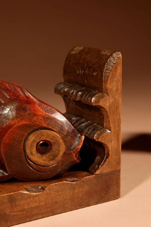 A pair of carved brown wooden bookends depicting goldfish figures mounted on angular wooden bases. View V