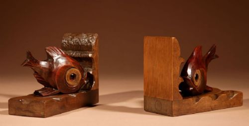 A pair of carved brown wooden bookends depicting goldfish figures mounted on angular wooden bases. View VII