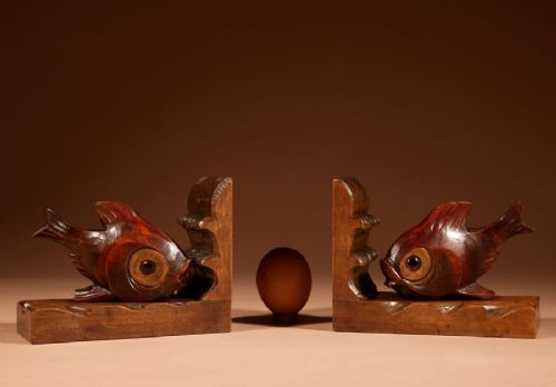 A pair of carved brown wooden bookends depicting goldfish figures mounted on angular wooden bases. View IX