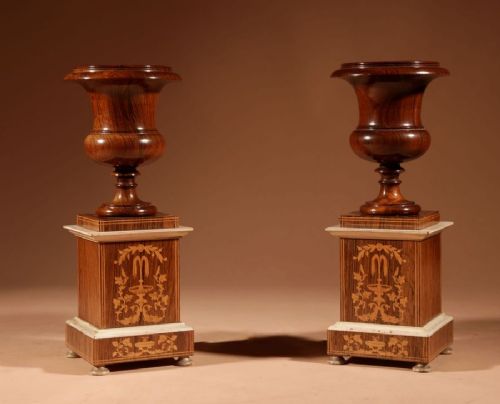 A French Louis Philippe portico mantel clock set featuring floral wood inlay, architectural columns, a gilt metal pendulum, and two matching urn side pieces on decorative pedestals. View VI