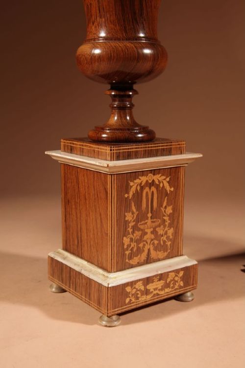 A French Louis Philippe portico mantel clock set featuring floral wood inlay, architectural columns, a gilt metal pendulum, and two matching urn side pieces on decorative pedestals. View IX