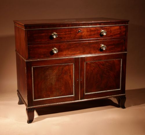 fig 1. A Regency mahogany library secretaire featuring a pull-out writing drawer with an adjustable slope, brass handles, and lower cabinet doors opening to reveal pull-out tray shelves.