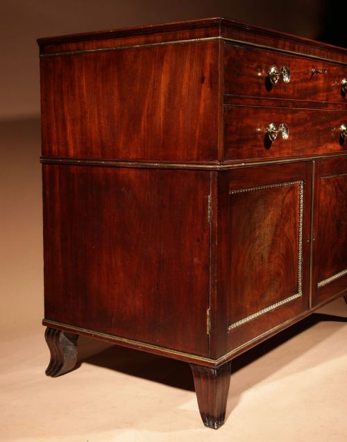 fig 2. A Regency mahogany library secretaire featuring a pull-out writing drawer with an adjustable slope, brass handles, and lower cabinet doors opening to reveal pull-out tray shelves.