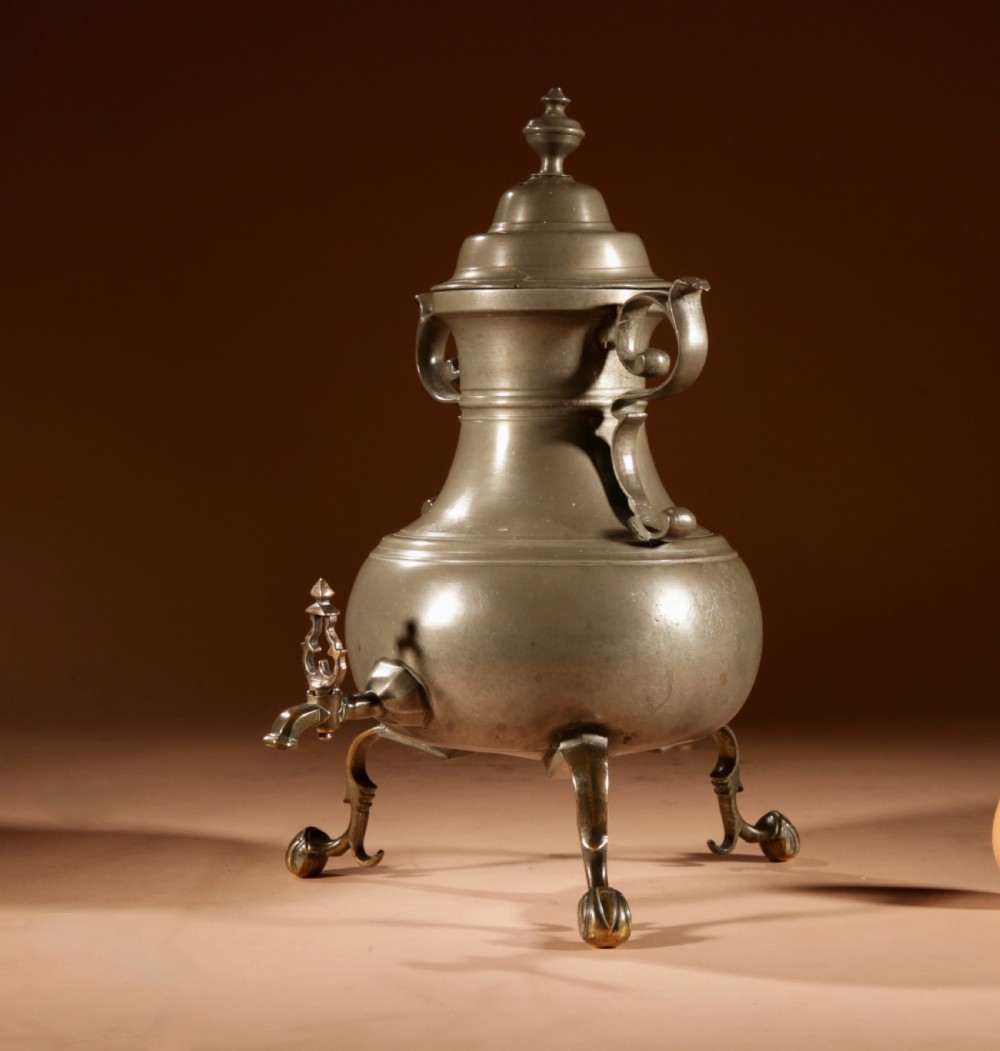 An 18th-century Dutch pewter coffee urn featuring a bulbous body, brass spigot, twin handles, and tripod bronze legs. View III