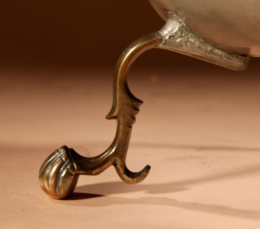 An 18th-century Dutch pewter coffee urn featuring a bulbous body, brass spigot, twin handles, and tripod bronze legs. View X