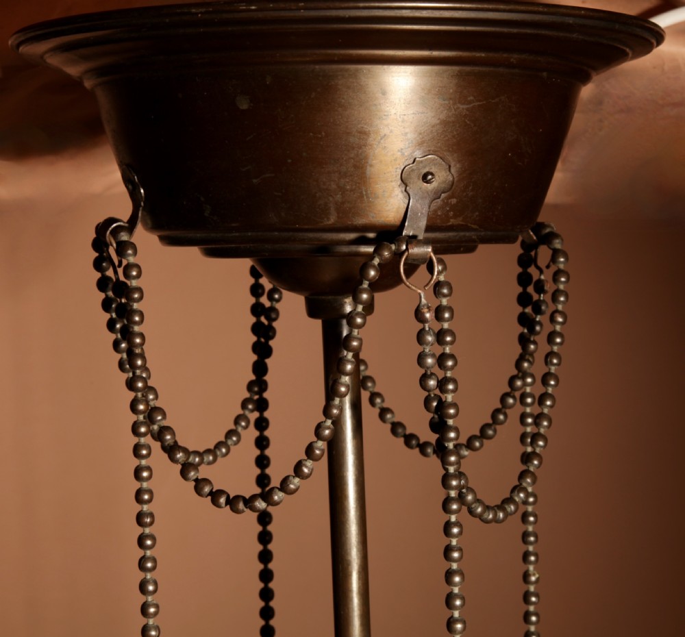 An early 20th-century Amsterdam School pendant light with a copper and brass frame, suspended by chain links, enclosing a pleated cream fabric shade. View V