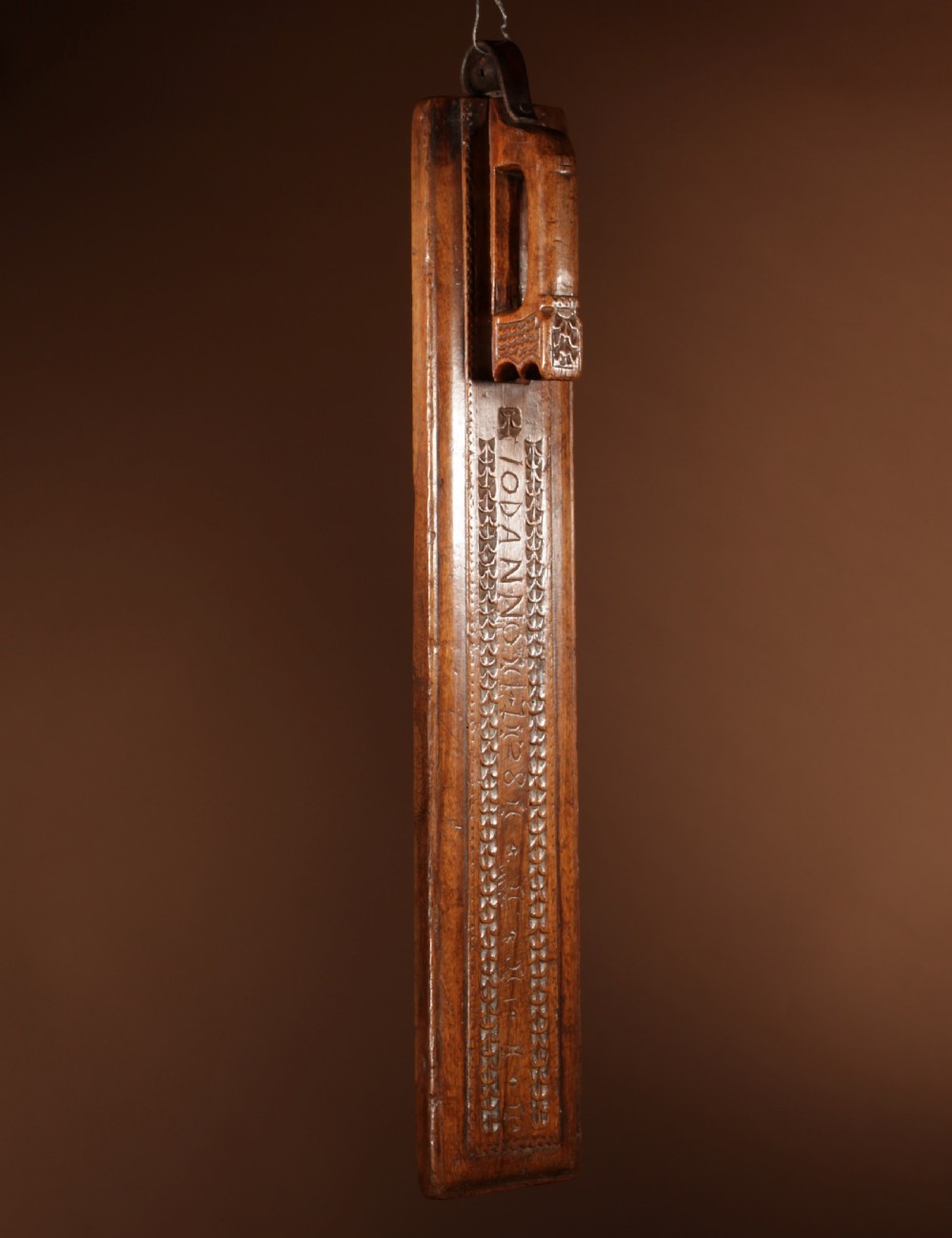 A hand-carved 18th-century Norwegian wooden mangle board with geometric chip carving, dated 1728, featuring a raised carved handle at one end. View II