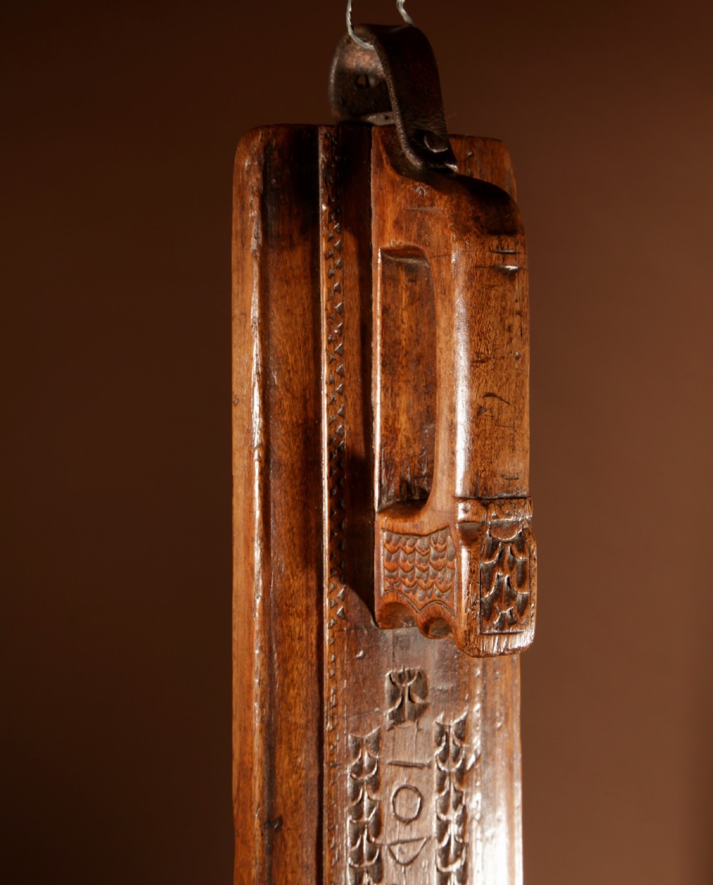 A hand-carved 18th-century Norwegian wooden mangle board with geometric chip carving, dated 1728, featuring a raised carved handle at one end. View V