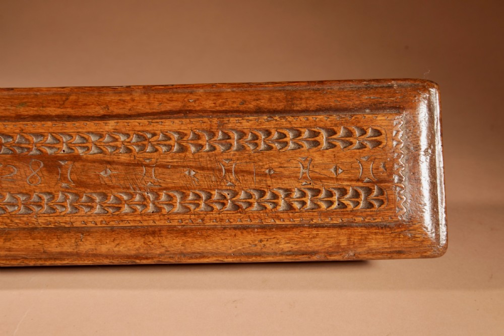 A hand-carved 18th-century Norwegian wooden mangle board with geometric chip carving, dated 1728, featuring a raised carved handle at one end. View X