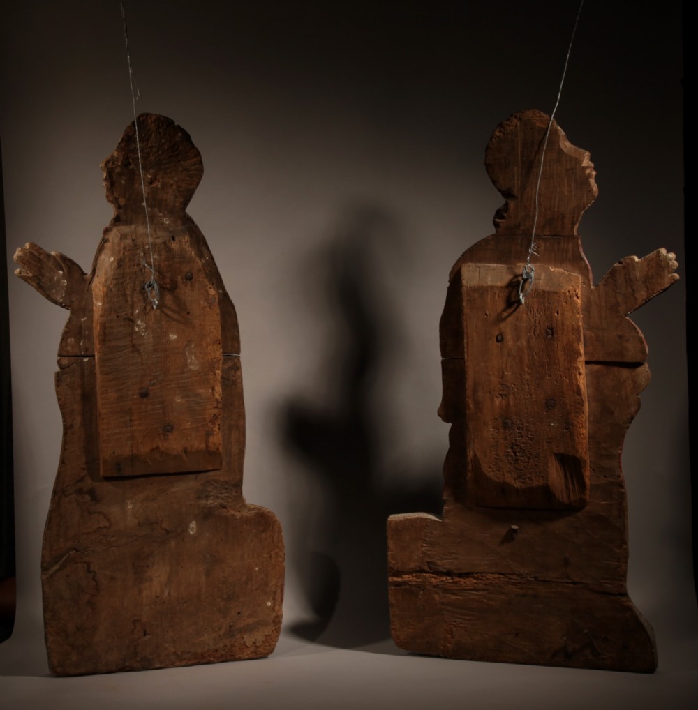 A pair of 16th-century carved wood polychrome relief sculptures depicting a kneeling man and woman facing each other with hands folded in prayer. View III