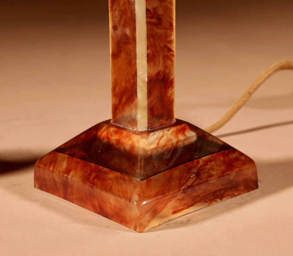 A small Art Deco table lamp made from marbled amber brown and cream celluloid with a faceted geometric shade. View III