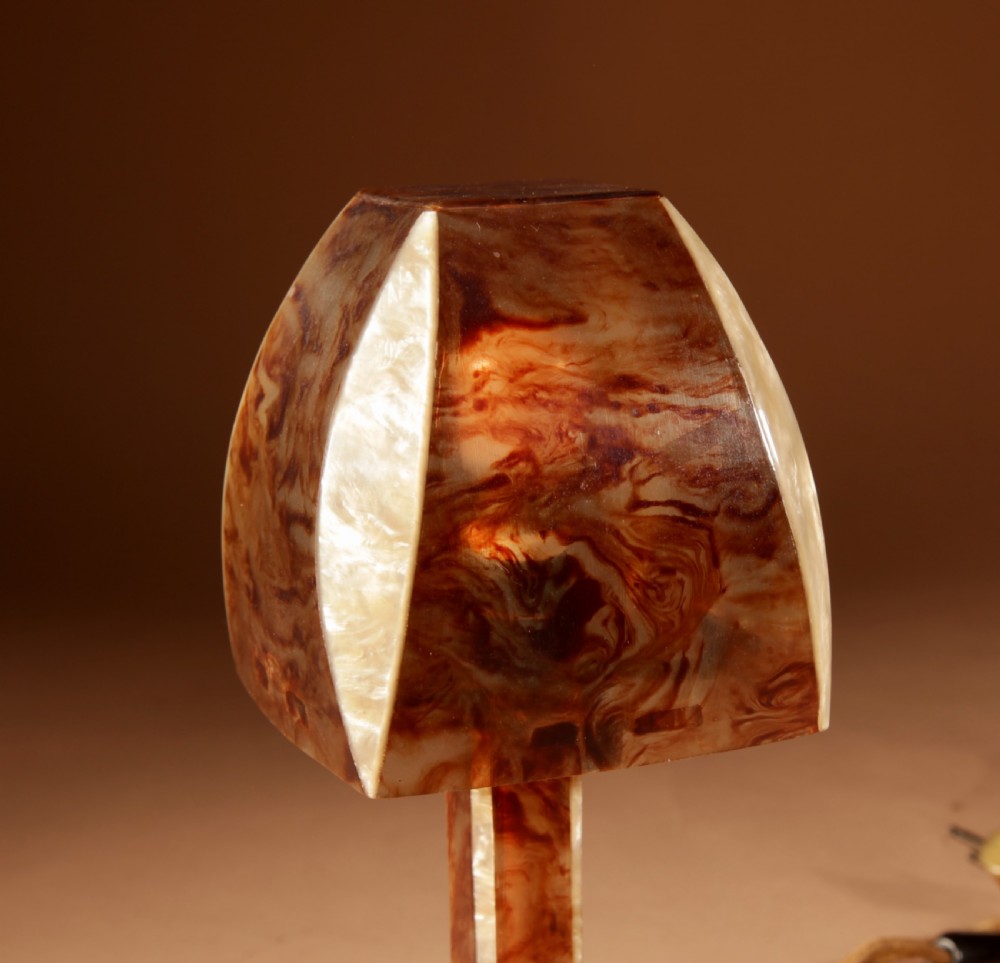 A small Art Deco table lamp made from marbled amber brown and cream celluloid with a faceted geometric shade. View IV