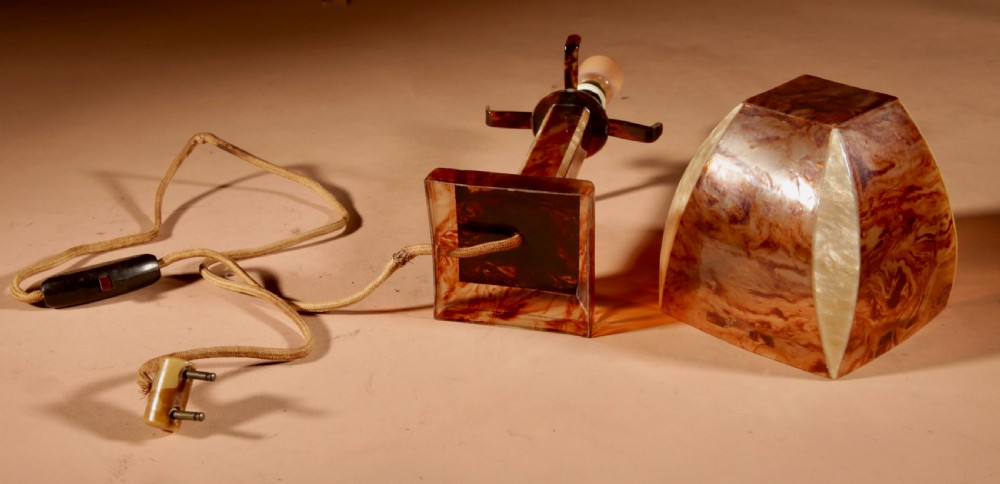 A small Art Deco table lamp made from marbled amber brown and cream celluloid with a faceted geometric shade. View VIII