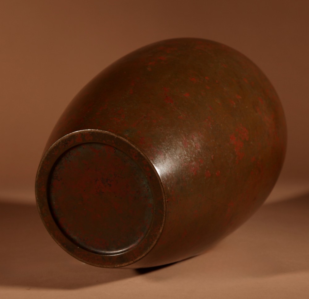 A Japanese bronze vase with a mottled red and brown patinated surface and an ovoid silhouette. View III