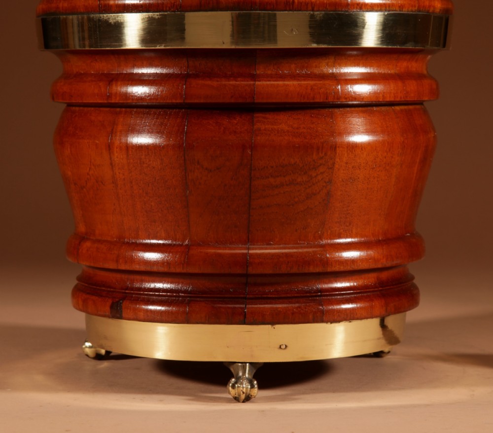 A coopered mahogany circular planter featuring polished brass banding and small brass feet. View II