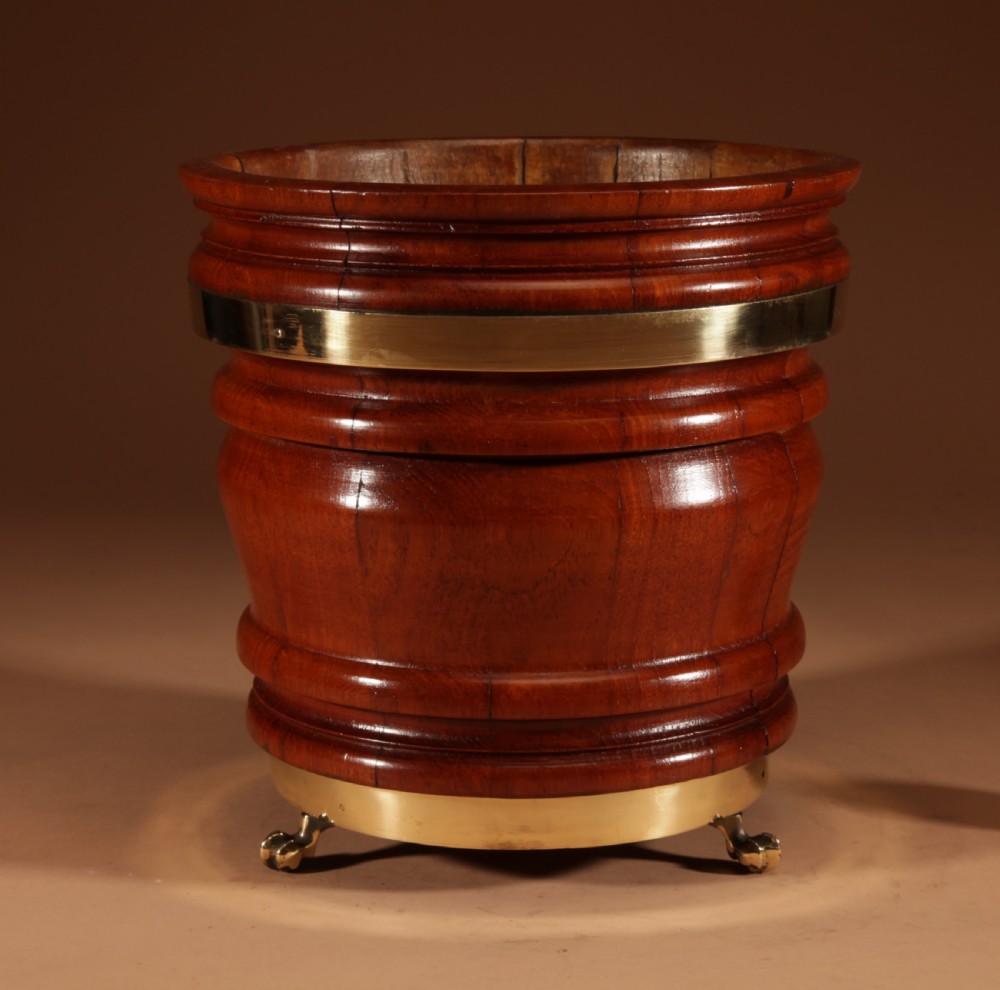 A coopered mahogany circular planter featuring polished brass banding and small brass feet. View III
