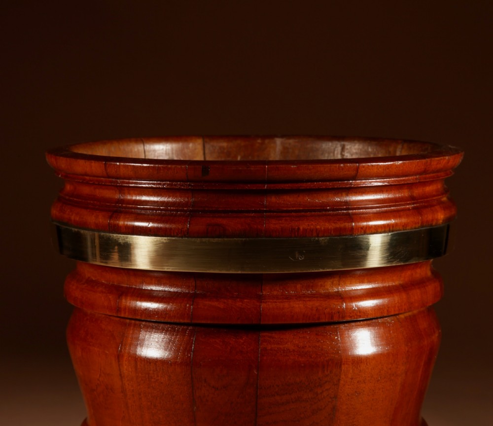 A coopered mahogany circular planter featuring polished brass banding and small brass feet. View IV