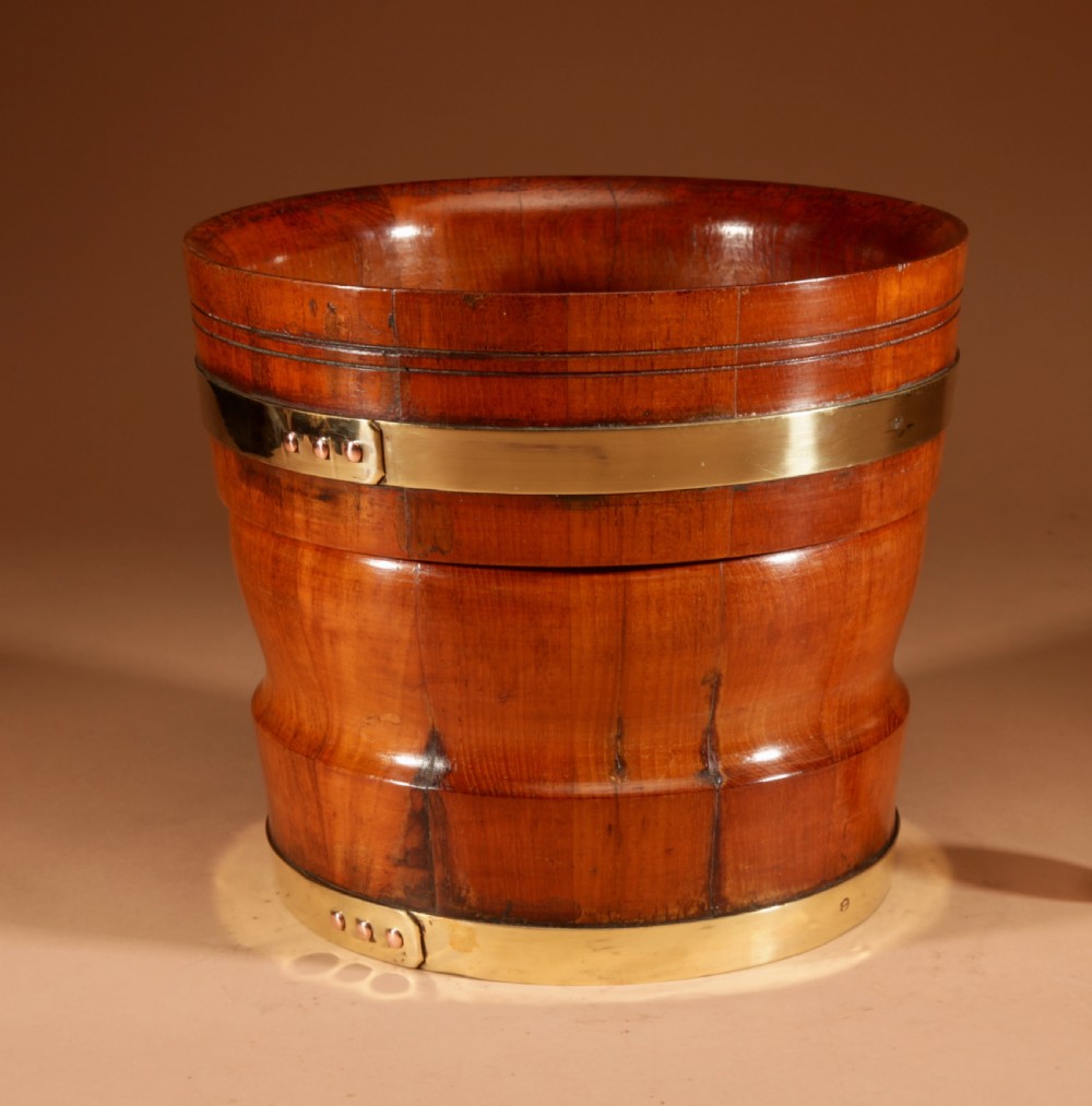 A turned teak planter featuring brass binding bands around the upper rim and base. View II