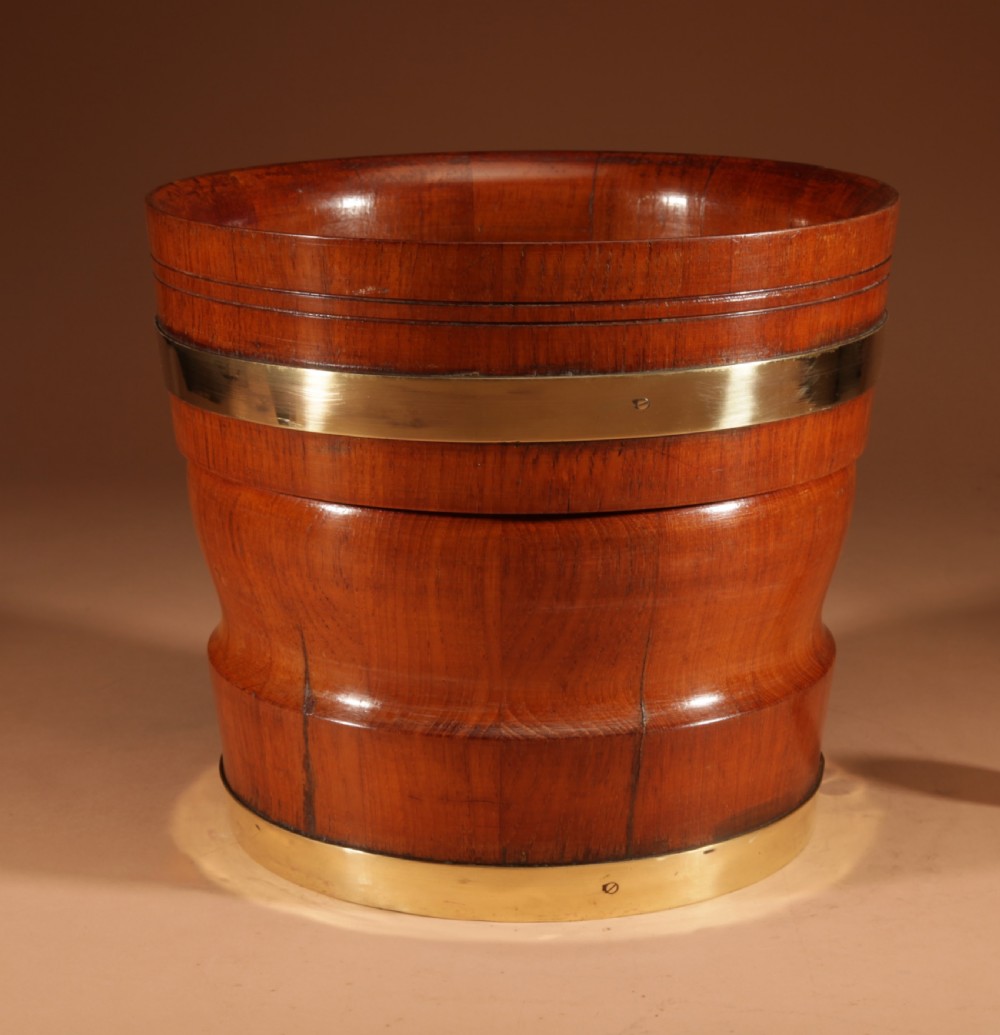 A turned teak planter featuring brass binding bands around the upper rim and base. View III