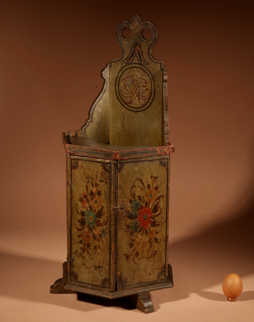 An 18th-century miniature Dutch Hindeloopen style green painted wooden doll chair featuring hand-painted floral motifs and an enclosed cabinet base.