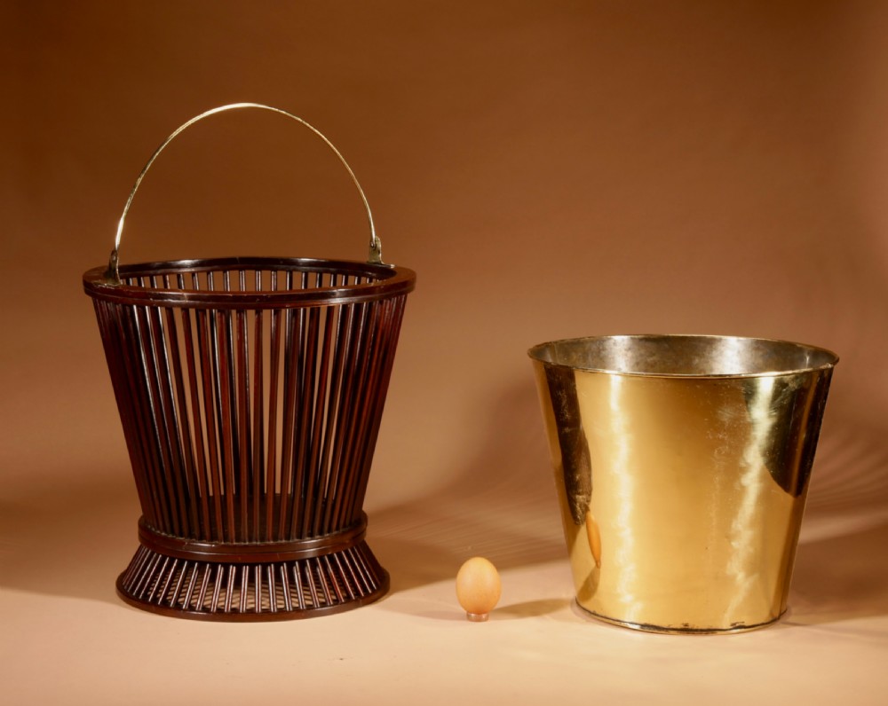 A 19th-century mahogany peat bucket constructed with open vertical spindles, a fitted brass interior liner, and a swinging brass handle. View VII