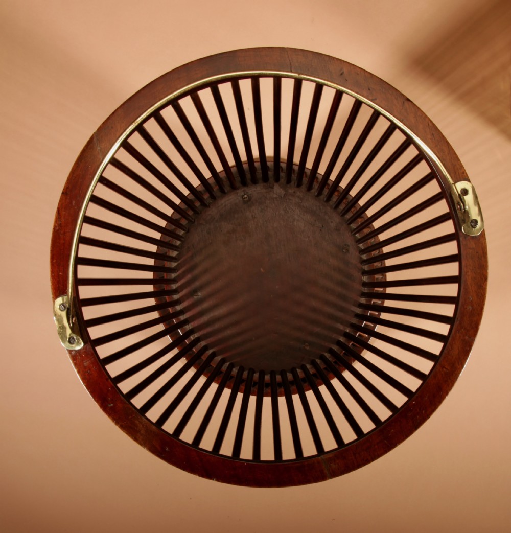 A 19th-century mahogany peat bucket constructed with open vertical spindles, a fitted brass interior liner, and a swinging brass handle. View XI