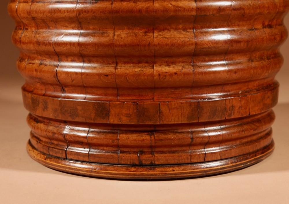 A tapered, coopered walnut bucket featuring horizontal ribbed bands, a fitted brass liner, and a brass swing handle. View VI