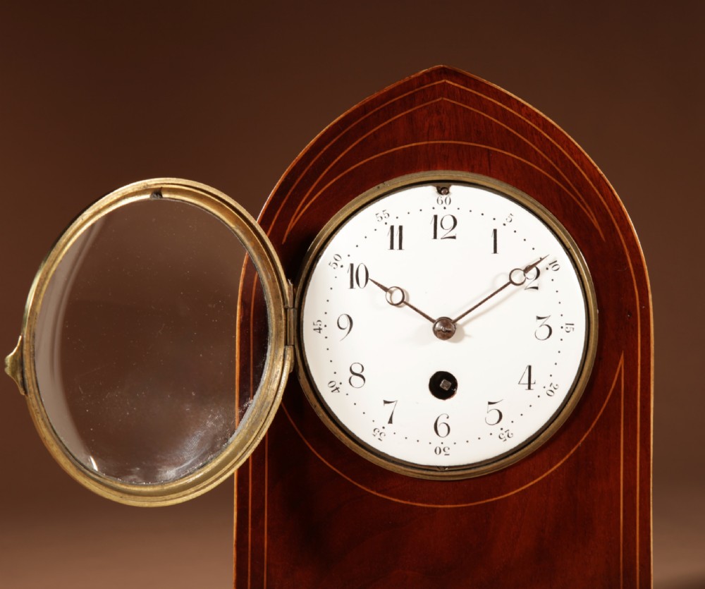 An Edwardian inlaid mahogany mantel clock with a lancet arch top, white enamel dial with Arabic numerals, and brass bun feet. View III