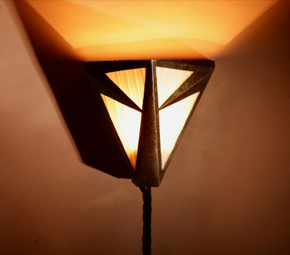 An Amsterdam School style triangular copper wall sconce featuring hand-chased geometric metalwork and pleated cream fabric panels. View III