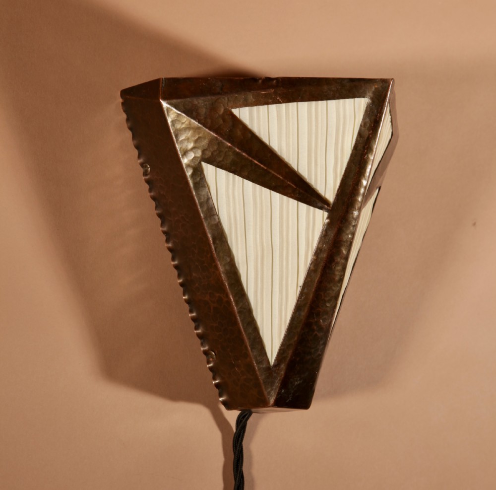 An Amsterdam School style triangular copper wall sconce featuring hand-chased geometric metalwork and pleated cream fabric panels. View IV