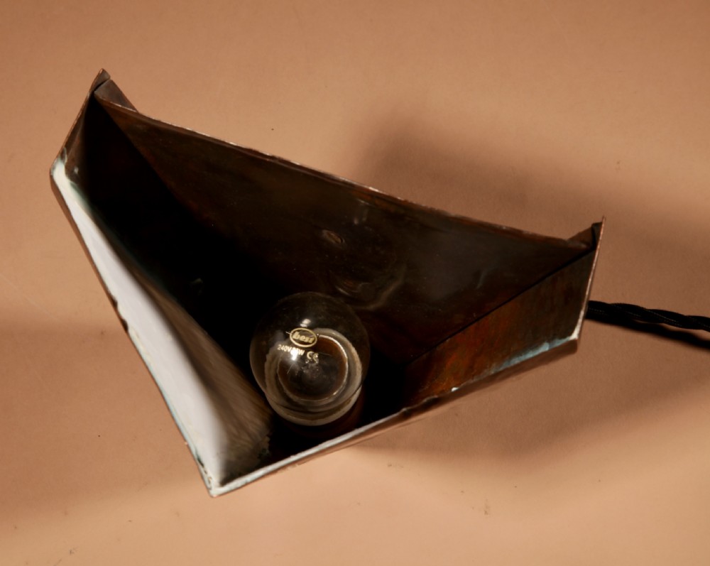 An Amsterdam School style triangular copper wall sconce featuring hand-chased geometric metalwork and pleated cream fabric panels. View VIII