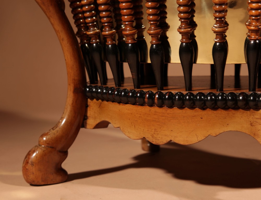 An oval Victorian walnut peat bucket featuring turned dual-tone spindles, four curved legs, and a swing-handled brass liner. View V