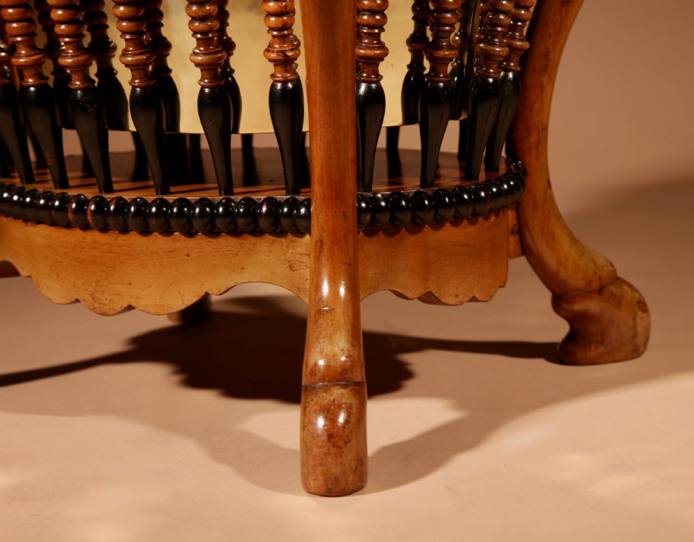 An oval Victorian walnut peat bucket featuring turned dual-tone spindles, four curved legs, and a swing-handled brass liner. View VII