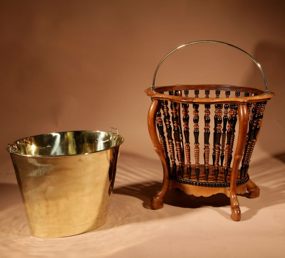 An oval Victorian walnut peat bucket featuring turned dual-tone spindles, four curved legs, and a swing-handled brass liner. View XII