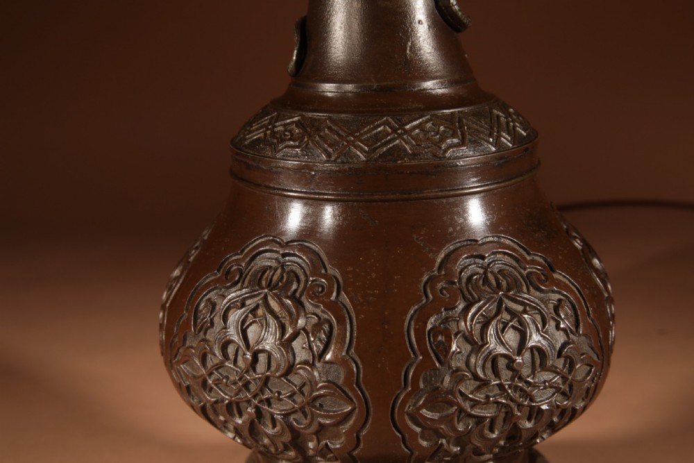 A dark patinated metal table lamp with relief dragon decoration, fitted with a pleated flared lampshade. View IV