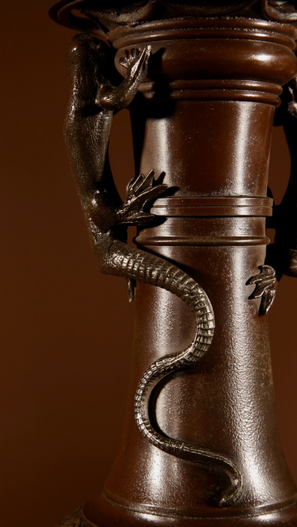 A dark patinated metal table lamp with relief dragon decoration, fitted with a pleated flared lampshade. View VI