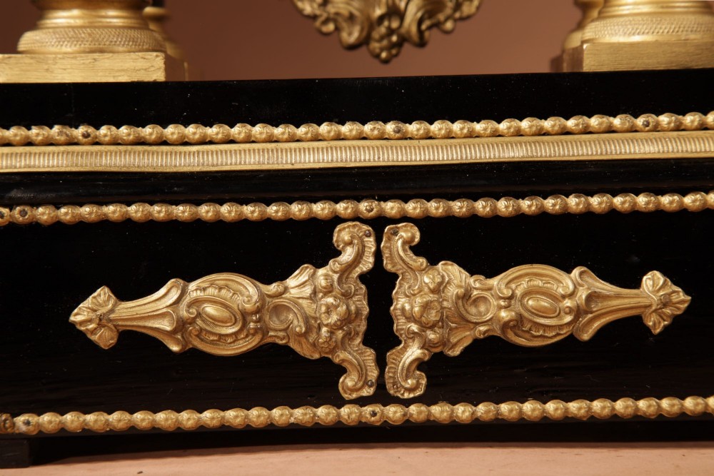 An ebonised wooden portico clock featuring four spiral columns with gilded mounts framing a central white enamel dial and decorative pendulum. View IV