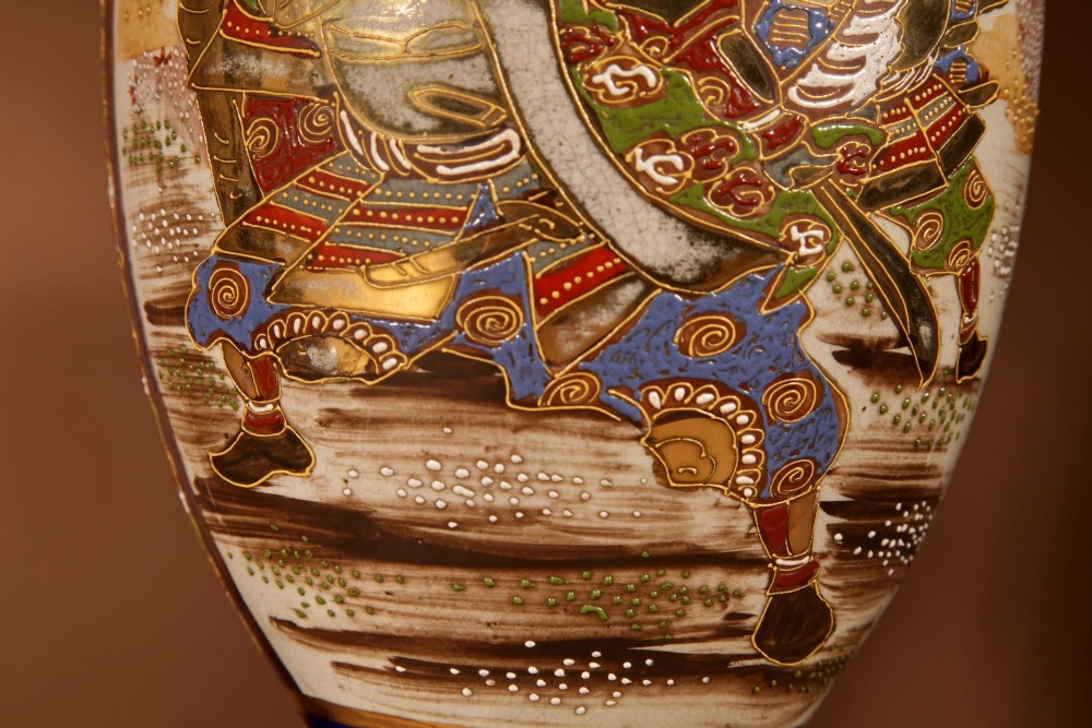 A pair of Japanese Satsuma ceramic table lamps featuring hand-painted figure scenes, cobalt blue accents, dark wooden bases, and cream pleated lampshades. View IX