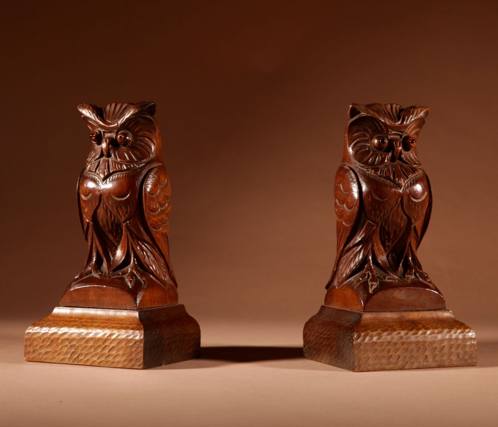 A pair of hand-carved dark wood owl figures with glass eyes mounted on carved wooden bases. View III