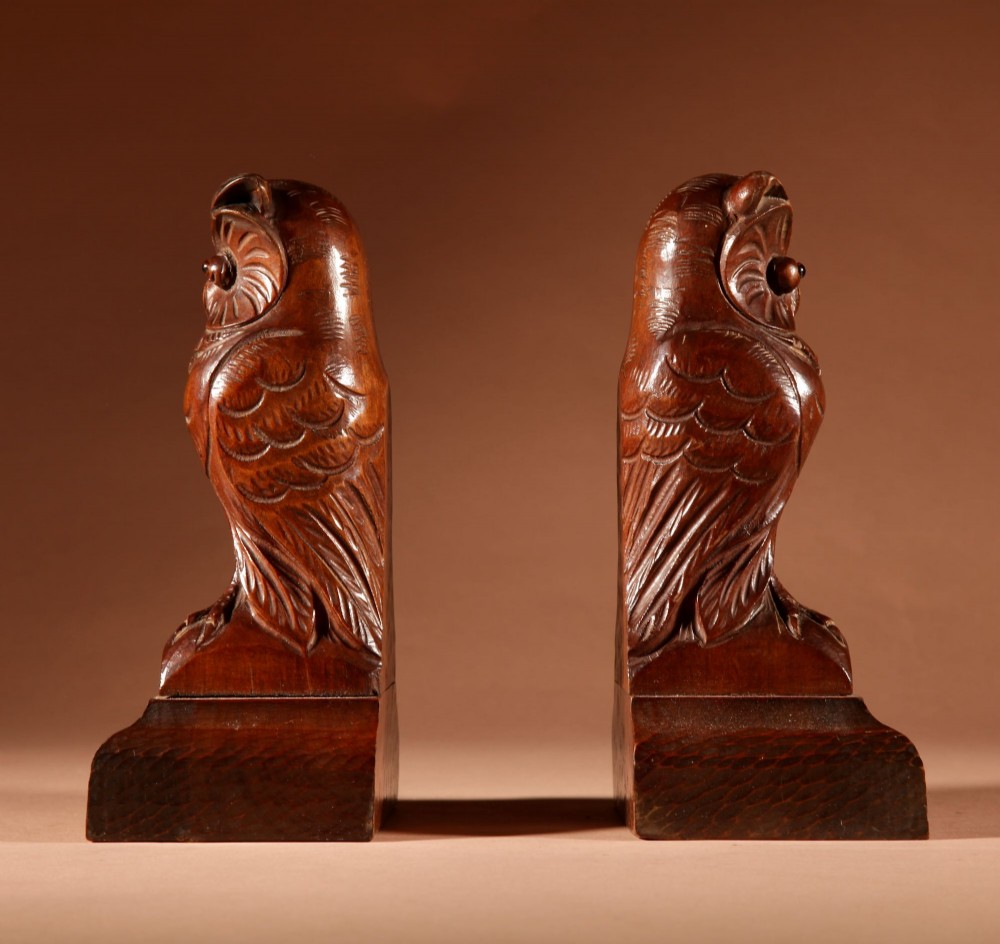 A pair of hand-carved dark wood owl figures with glass eyes mounted on carved wooden bases. View V